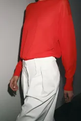 Top de punto color rojo, de cuello redondo y manga larga.