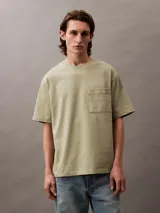 Remera color verde oliva de corte holgado, con cuello redondo, mangas cortas y bolsillo en el pecho con logo bordado.