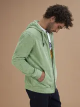 Campera con capucha de toalla de algodón color verde azulado, con cierre frontal y bolsillos laterales.