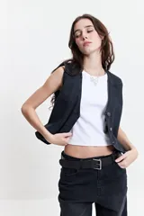 Chaleco de jean negro con corte moderno, escote en V y aberturas.