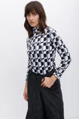 Polera de cuello alto con estampado geométrico en blanco, negro y gris.