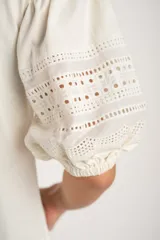 Remera negra de algodón con mangas 3/4 abullonadas con detalle de encaje calado. Corte al cuerpo.