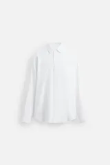 Camisa celeste de algodón, corte regular fit, con cuello italiano, manga larga con puños abotonados y cierre frontal con botones.