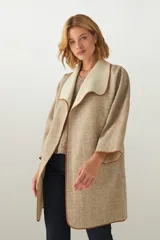 Tapado marrón de largo medio, abierto, con cuello y envivado. Hecho 100% en Uruguay con tela 100% lana fina sin teñir, diseñada exclusivamente por Don Baez.