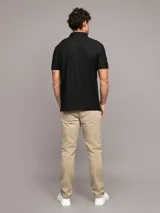 Chomba negra de manga corta con cuello polo y cremallera corta en el frente. Logo de Calvin Klein bordado en el pecho.