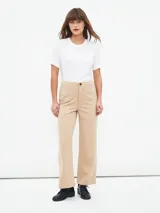 Pantalón beige de corte acampanado con bolsillos delanteros con solapa y botón.