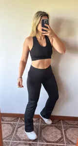 Conjunto deportivo negro compuesto por un top con breteles anchos y calza recta con cintura alta.