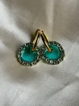 Par de aros dorados con dije circular de resina color terracota con glitter y borde de strass.