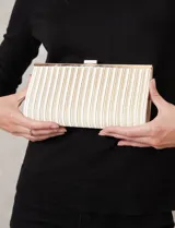 Cartera tipo clutch de Jessica McClintock, con diseño rectangular y acabado plisado en color crema. Cuenta con cierre superior metálico y estructura rígida.
