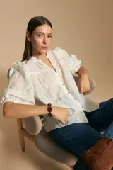 Camisa blanca de manga corta abullonada con terminación elastizada y cuello con leve frunce. Presenta una estampa floral integral.