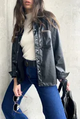 Sobrecamisa de eco cuero color negro con detalles de tachas y cierre frontal.