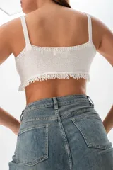 Top crop tejido de punto color blanco con escote en V y breteles anchos.