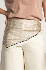Pañuelo cuadrado de seda color beige con lunares blancos y borde negro.