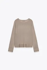 Jersey de punto color beige con cuello redondo y manga larga.