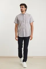 Camisa celeste de manga corta con cuello abotonado y bolsillo en el pecho.