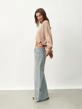 Buzo corto color beige con cuello redondo y mangas largas.
