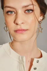 Aro de argolla dorada con dije de corazón calado, adornado con pequeños cristales brillantes.