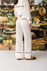 Pantalón acampanado color manteca con costuras en contraste color marrón.