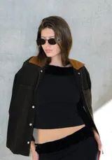 Campera de jean con cuello clásico, cierre frontal con botones metálicos, dos bolsillos de parche en el pecho y estampado floral en tonos verdes y marrones.