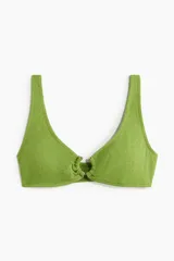 Top de bikini verde con textura, breteles anchos y anilla revestida en el centro del busto.