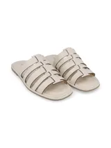 Sandalia chatita color beige con capellada de tiras de cuero cortadas a láser.