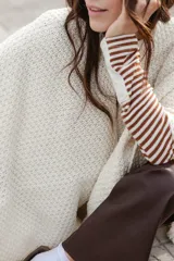 Ruana tejida en lana merino color amarillo pastel, con terminación de flecos.