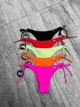 Parte inferior de bikini color fucsia vibrante, estilo vedetina con tiras ajustables a los lados.