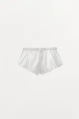 Shorts de popelín blanco con cintura elástica y botones decorativos.