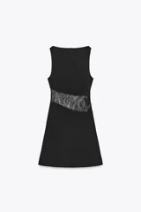 Vestido corto negro de cuello barco y sin mangas, con panel lateral de encaje floral transparente.