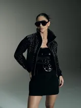 Chaqueta negra con cierre frontal, cuello alto y diseño acolchado en la parte superior.
