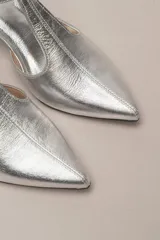 Sandalia de cuero color bordó, con acabado charolado, punta fina y tacón cuadrado de 5 cm. Presenta una tira en forma de T sobre el empeine y una correa con hebilla alrededor del tobillo.