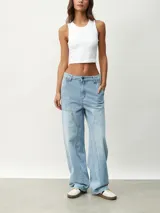 Pantalón de jean celeste, de corte ancho y tiro alto, con bolsillos laterales y traseros.