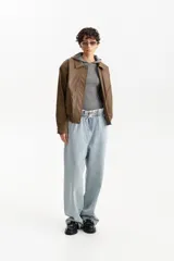 Chaqueta estilo bomber de cuero sintético color marrón, con cuello camisero, cierre frontal y bolsillos delanteros con solapa.