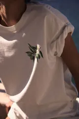 Remera blanca de corte amplio con estampado de rama de olivo en el pecho.