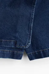 Short pollera cruzado de tiro alto en sarga de algodón color azul denim con botón a un lado, cierre oculto adelante y bolsillos insertados decorativos atrás.