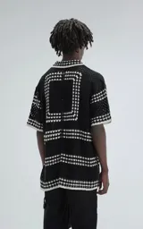Camisa de manga corta tejida a crochet, color negro con detalles en blanco, de corte oversize.