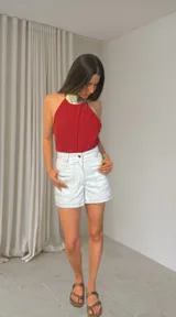 Short blanco tiza de tiro medio-alto, confeccionado en algodón con pespuntes negros visibles, bolsillos funcionales y terminaciones premium.