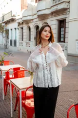 Camisa color beige con encaje en la parte delantera y en las mangas, de corte holgado.
