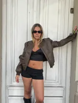 Campera bomber marrón de cuero sintético con cierre frontal y puños elastizados.