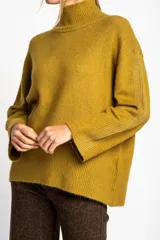 Polera color crema de tejido de punto, con cuello alto y mangas largas.
