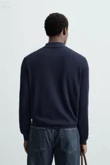 Polo azul marino de punto ligero tejido en hilatura con mezcla de seda y algodón. Cuello solapa con cierre frontal de botonadura, manga larga y acabados en rib.