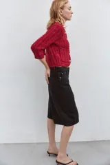 Chaqueta roja de tweed con cuello redondo, manga francesa, bolsillos delanteros y cierre frontal con botones dorados.