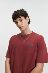 Remera color ladrillo de manga corta con cuello redondo y estampado pequeño en el pecho.