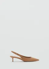 Zapato destalonado color beige con punta fina, detalle de tachuelas y cierre con hebilla.