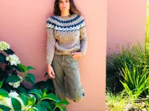 Sweater tejido a mano color mostaza con diseño geométrico en el canesú en tonos azul marino, blanco y verde.