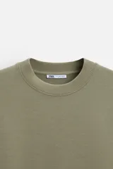 Sudadera negra de corte relaxed fit, confeccionada en tejido interlock de algodón con elasticidad. Tiene cuello redondo, manga corta y bajo acabado en rib.