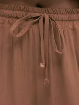 Pantalón palazzo negro de crepe con cintura elastizada, bolsillos laterales y terminaciones con logo en cobre.