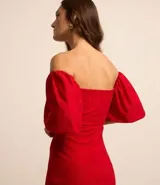 Vestido corto evasê rojo con bordado floral, escote cuadrado, mangas cortas abullonadas y espalda descubierta.