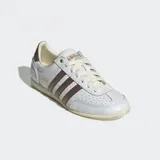 Championes Adidas modelo Japan confeccionados en cuero blanco con detalles metálicos en color bronce en las tres tiras laterales y el talón. Poseen un diseño de perfil bajo inspirado en los años 60, con puntera reforzada de doble costura, cierre de cordones y suela de caucho delgada.