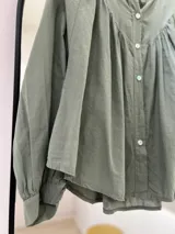Camisa verde oliva de manga larga con puño, cuello mao y cierre frontal con botones.